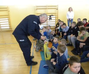 Policjant rozdaje dzieciom odblaski