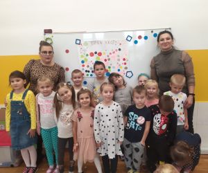 Dzieci z nauczycielkami na zdjęciu grupowym ubrani w stroje z kropkami