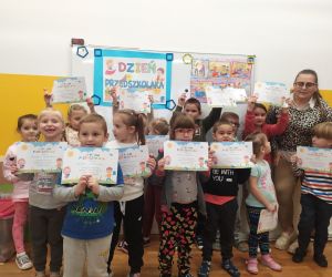 Dzieci na wspólnym zdjęciu z nauczycielką z dyplomami super przedszkolaka