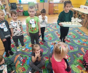 Dziewczynka trzyma tacę z babeczkami dla chłopców