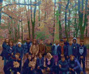 Grupa młodzieży przed obeliskiem na tle parku