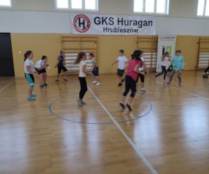 Dzieci biegają po hali sportowej