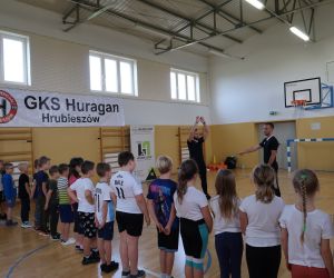 Trener pokazuje dzieciom ćwiczenia