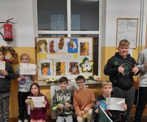 Uczniowie biorący udział w konkursie na portret Jesieni trzymają dyplomy i nagrody