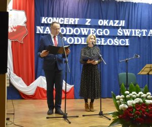 Dwie osoby stoją na scenie.