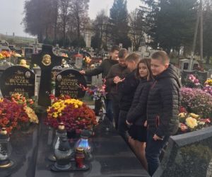 Uczniowie klasy szóstej zapalają znicz na grobie lokalnego bohatera walk narodowowyzwoleńczych