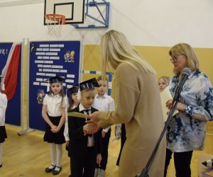 Pani dyrektor wręcza uczniowi klasy pierwszej pamiątkowy dyplom