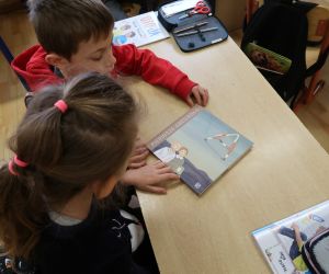 Dziewczynka i chłopiec oglądają książeczkę