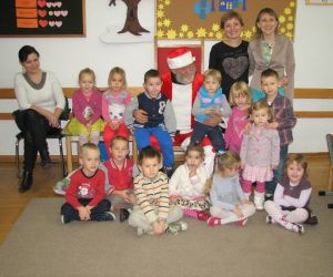 Dzieci z opiekunkami w klasie lekcyjnej.