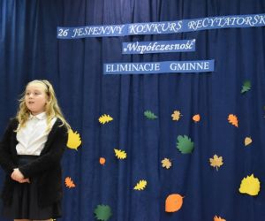 Zdjęcie przedstawia recytującą dziewczynkę.