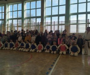 Wspólne zdjęcie adeptów karate i trenera z dziećmi z przedszkola i szkoły