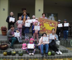 Na zdjęciu widoczna jest grupa osób pozująca do zdjęcia przed budynkiem.