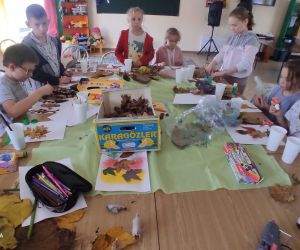 Na zdjęciu widoczne są dzieci wykonujące prace plastyczne.