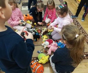 Na zdjęciu widoczne są dzieci bawiące się pluszowymi zabawkami.