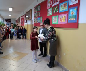 Nauczycielka wręcza uczennicy dyplom i nagrodę