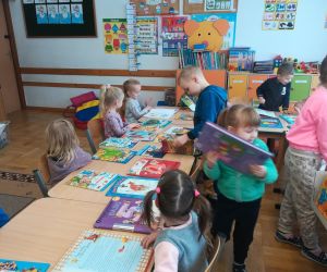 Dzieci oglądają książki przywiezione z Biblioteki