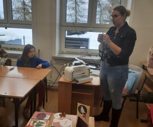 Prowadząca warsztaty prezentuje działanie maszynki do scrapbookingu
