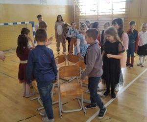 Uczniowie tańczą wokół ustawionych w kole krzeseł