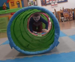 Chłopiec przechodzi przez materiałowy tunel