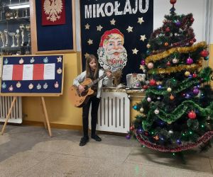 Dziewczynka gra na gitarze i śpiewa pastorałkę 