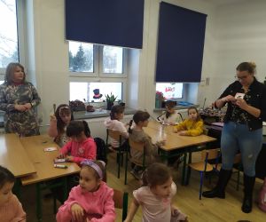 Prowadząca warsztaty tłumaczy jak wykonać kartkę