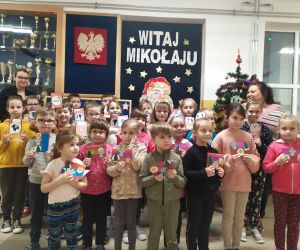 Wspólne zdjęcie prowadzących warsztaty z dziećmi i ich kartkami świątecznymi