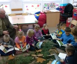 Leśnik opowiada coś zaciekawionym dzieciom