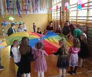 Zdjęcie przedstawia dzieci bawiące się chustą animacyjną.