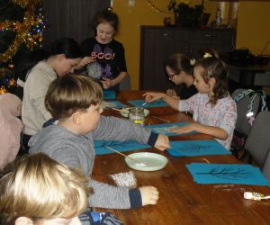Zdjęcie przedstawia grupę dzieci podczas warsztatów plastycznych.
