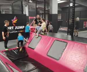 Zdjęcie przedstawia dzieci bawiące się w parku trampolin.