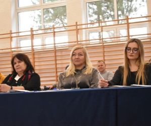 Osoby siedzą na sali