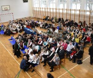 Osoby siedzą na sali