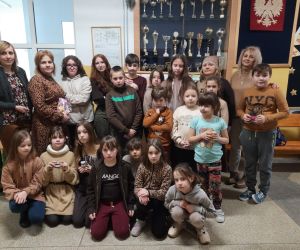 Grupa nauczycieli i uczniów w brązowych strojach