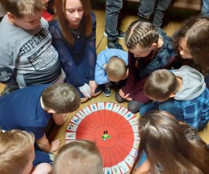 Grupa dzieci gra w grę przy użyciu spinera. 
