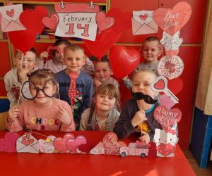 Dzieci z grupy młodszej pozują do zdjęcia przy fotobudce