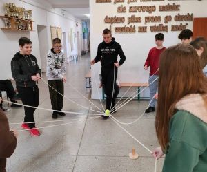 Grupa osób wewnątrz budynku, gra w zabawę integracyjną przy użycia 