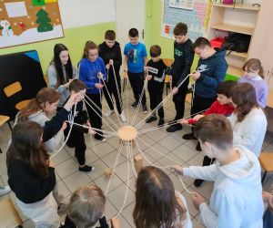 Grupa osób wewnątrz budynku, gra w zabawę integracyjną przy użycia 