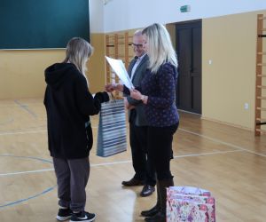 Uczennica odbiera nagrodę i dyplom