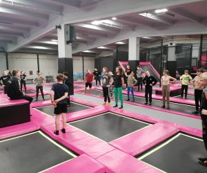 Uczniowie w parku trampolin podczas rozgrzewki z instruktorami