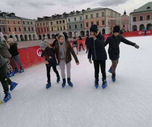 Grupa dziewcząt i chłopców jeździ na łyżwach