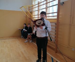 Uczeń stoi przy mikrofonie