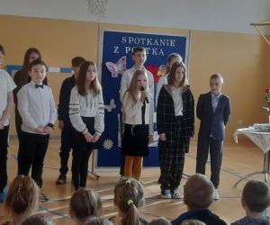 Dziewczynka na tle grupy mówi do mikrofonu