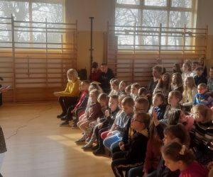 Poetka mówi do siedzącej grupy uczniów