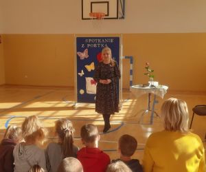 Chłopiec i dziewczynka wręczają kwiaty poetce