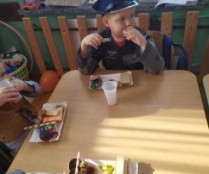 Chłopiec w stroju policjanta je smakołyki.
