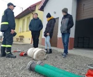 Druh z Ochotniczej Straży Pożarnej prezentuje sprzęt do gaszenia pożarów.