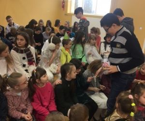 Chłopcy wręczają dziewczynkom lizaki