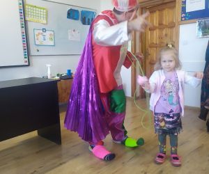 Dziewczynka pomaga klaunowi w sztuczce