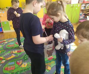 Dziewczynka z maskotką bierze cukierka 