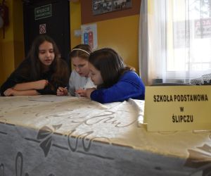 Zdjęcie przedstawia dzieci siedzące przy stole.